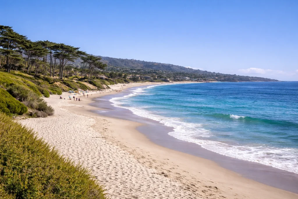  Top 5 places to visit in Carmel-by-the-Sea California,      Carmel Beach in Carmel-by-the-Sea with white sand, ocean waves, and cypress trees
